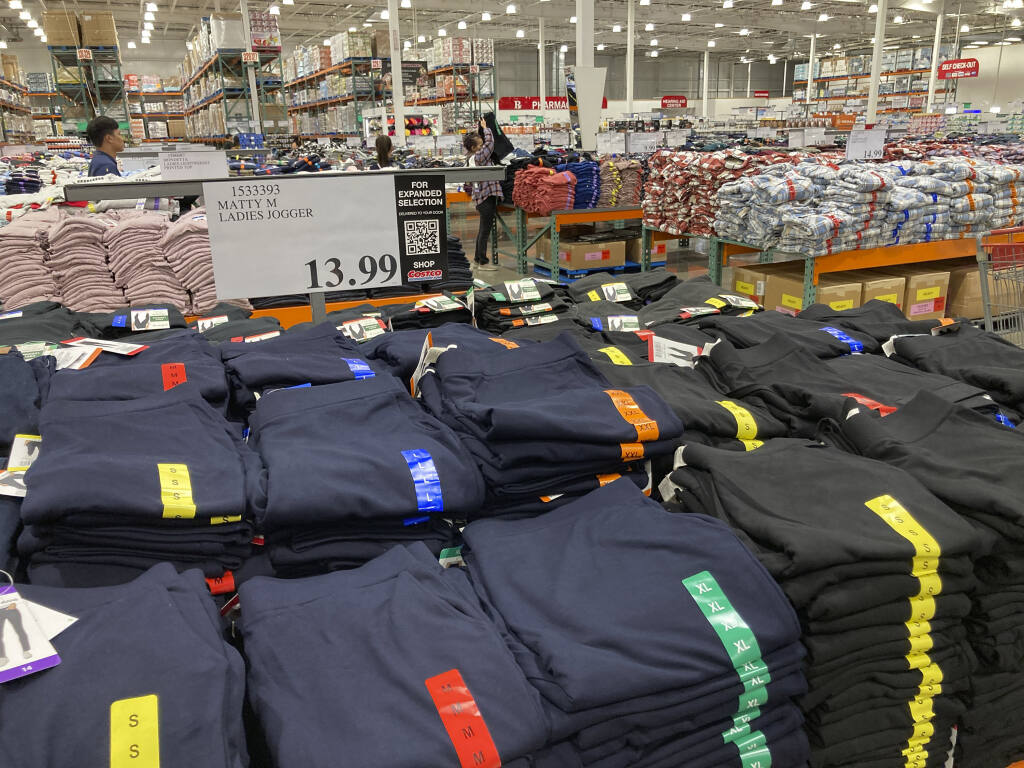 FILE - Clothing sits on tables for shoppers in a Costco warehouse Monday, Aug. 29, 2022, in Sheridan, Colo. The Federal Reserve is expected to raise its key short-term rate by a substantial three-quarters of a point for the third consecutive time Wednesday, Sept. 21. The goal is to slow consumer spending, reducing demand for homes, cars and other goods and services, eventually cooling the economy and lowering prices. (AP Photo/David Zalubowski)
