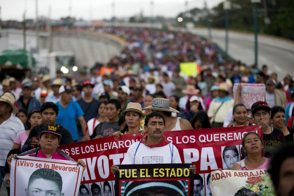 FILE - Relatives of the 43 missing Ayotzinapa teachers' college students lead a march marking the one-year anniversary of the students' disappearances in Chilpancingo, Mexico, Saturday, Sept. 26, 2015. Experts of the Inter American Human Rights Commission presented a report on Monday, March 28, 2022, that the Mexican Navy was also part of the cover-up of the disappearance of 43 university students in 2014. (AP Photo/Rebecca Blackwell, File)