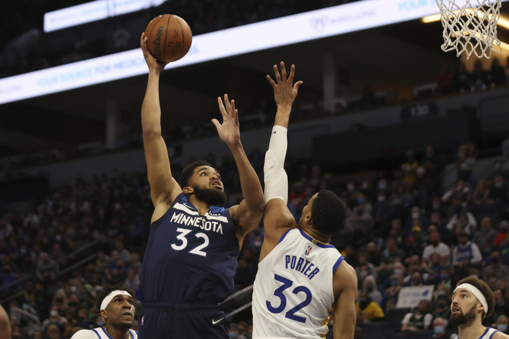 Minnesota Timberwolves center Karl-Anthony Towns (32) shoots the ball over Golden State Warriors forward Otto Porter Jr. (32) during the first half of an NBA basketball game, Sunday Jan. 16, 2022, in Minneapolis. (AP Photo/Stacy Bengs)