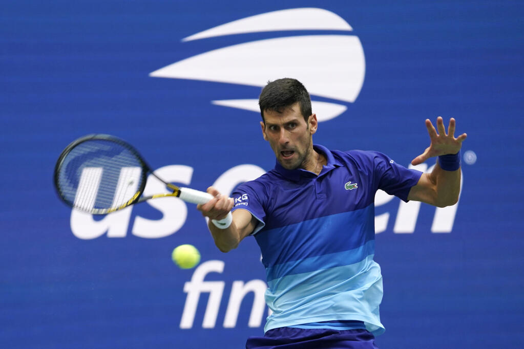 FILE - In this Sept. 12, 2021, file photo, Novak Djokovic, of Serbia, returns a shot to Daniil Medvedev, of Russia, during the men's singles final of the U..S. Open tennis championships in New York. Djokovic will not play in the U.S. Open, as expected, because he is not vaccinated against COVID-19 and thus is not allowed to travel to the United States. Djokovic announced his withdrawal from the year’s last Grand Slam tournament on Twitter on Thursday, Aug. 25, 2022, hours before the draw for the event was revealed. (AP Photo/John Minchillo, File)