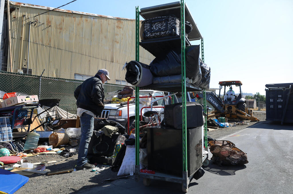 Rich, who declined to give his last name, begins packing up his belongings as the homeless encampments along Yolanda Avenue are removed in Santa Rosa on Thursday, May 6, 2021.  (Christopher Chung/ The Press Democrat)