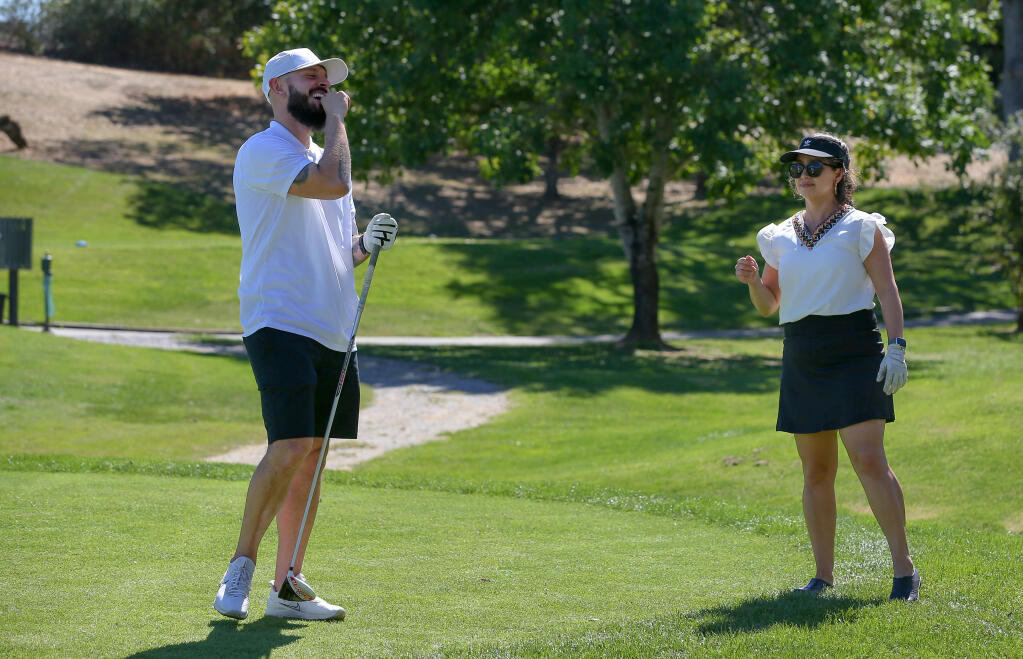 Herman G. Hernandez, left, laughs with Natali Torres as they play golf during the Hispanic Chamber of Commerce of Sonoma County’s Golfiesta fundraiser at Windsor Golf Club on Thursday, Sept. 22, 2022. (Christopher Chung/The Press Democrat)