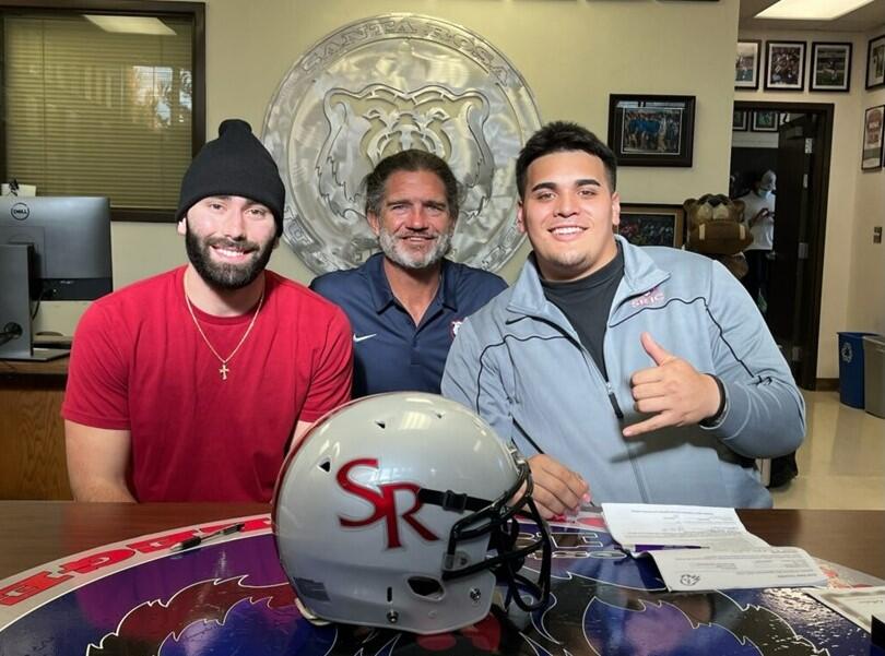 Santa Rosa Junior College quarterback Jake Simmons, left, and linebacker TJ Talamoni- Marcks, right, after signing paperwork to play at Division I schools in fall 2022. At center is SRJC football coach Lenny Wagner. (Santa Rosa Junior College)