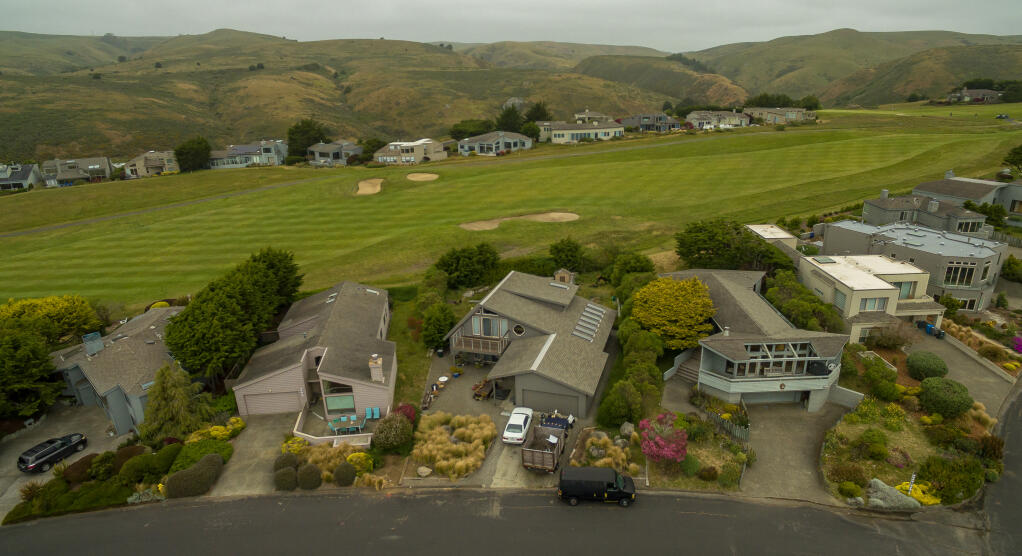 In a view from the air, vehicles sit in the driveway, center, of Tom and Christophe Pochari’s red-tagged house on Hummingbird Court in Bodega Bay, Monday, June 5, 2023. (Chad Surmick / The Press Democrat)