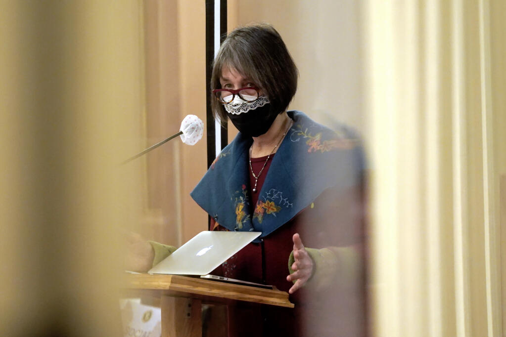 State Sen. Nancy Skinner, D-Berkeley, chair of the Senate Budget Committee, is seen between plexiglass as she urges lawmakers to approve a measure to provide eviction protections for renters at the Capitol in Sacramento, Calif., Thursday, Jan. 28, 2021. Both houses of the Legislature approved the bill to use $2.6 billion in federal stimulus money to pay off up to 80% of some tenants's unpaid rent but only if landlords agree to forgive the rest of their debt. The bills now go to Gov. Gavin Newsom who is expected to sign them into law. (AP Photo/Rich Pedroncelli)