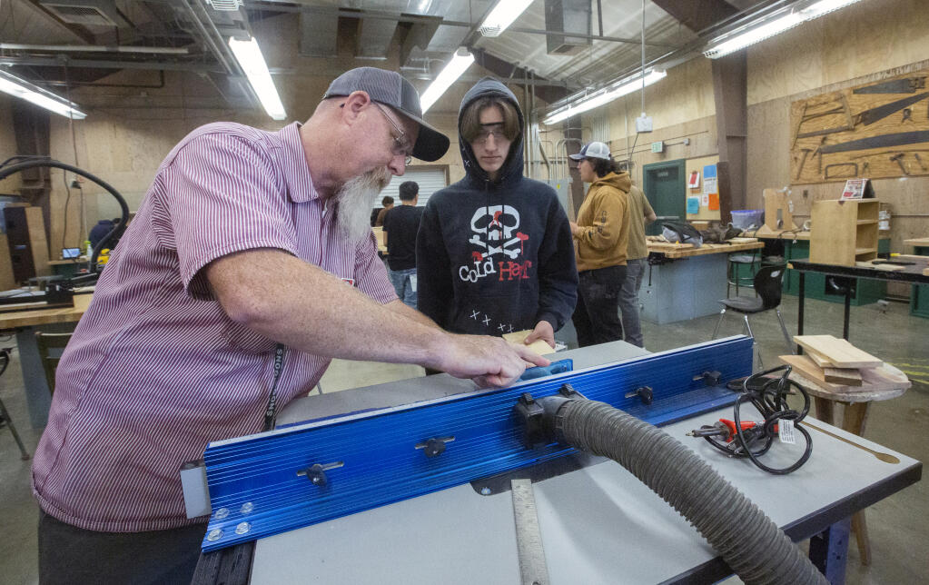 Teacher Drue Jacobs shows Cormac Rhodes, 17, how to round off an edge on the router table during a construction technology class at Sonoma Valley High School on Oct. 26. (Robbi Pengelly/Index-Tribune)