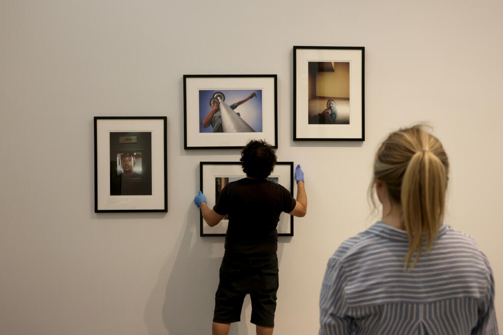 Curatorial Associate Twyla Ruby helps Raul Garcia hang photographs in preparation for the "Incorrect Museum" exhibition of Northern California art at the di Rosa Center for Contemporary Art in Napa, Wednesday, Aug. 23, 2023. (Beth Schlanker / The Press Democrat)