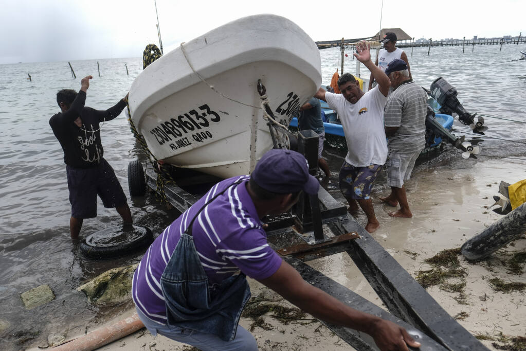 Fishermen pull in a boat before the arrival of Hurricane Delta in Puerto Juarez, Cancun, Mexico, Tuesday, Oct. 6, 2020. Hurricane Delta rapidly intensified into a potentially catastrophic Category 4 hurricane Tuesday on a course to hammer southeastern Mexico and then continue on to the U.S. Gulf coast this week. (AP Photo/Victor Ruiz Garcia)