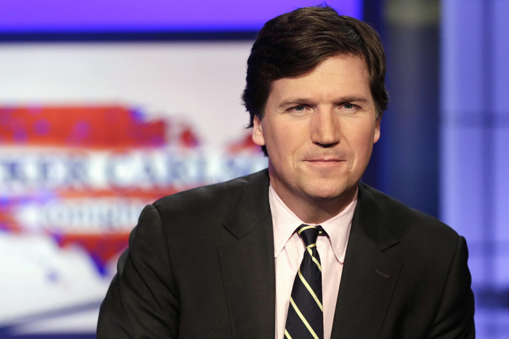 FILE - Tucker Carlson, host of "Tucker Carlson Tonight," poses for photos in a Fox News Channel studio on March 2, 2017, in New York. (AP Photo/Richard Drew, File)