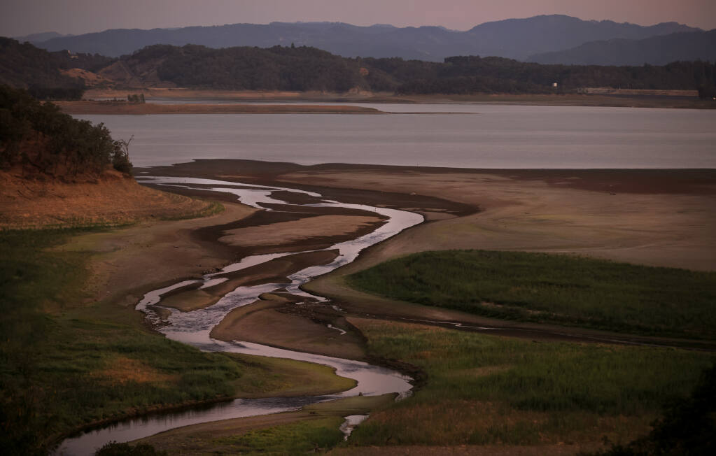 Twilight pastels accentuate the meandering, uneven flow from the east fork of the Russian River, draining in to the rapidly receding Lake Mendocino, Thursday, July 15, 2021, east of Ukiah. (Kent Porter / The Press Democrat) 2021