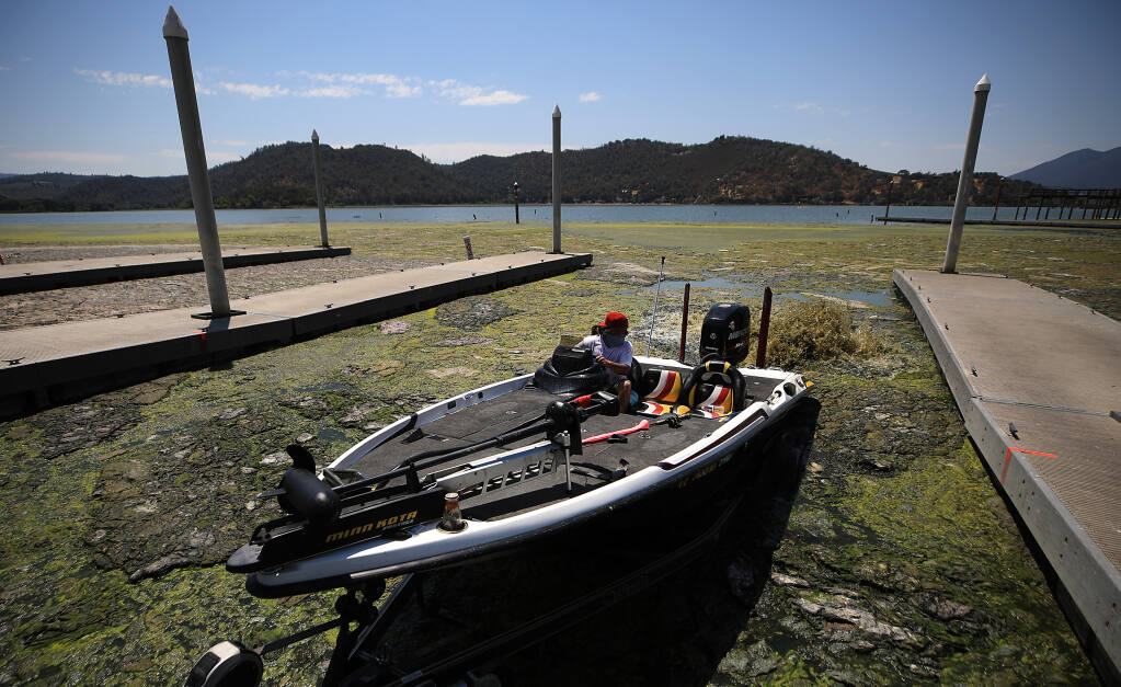 Matthew Davenport of Santa Rosa pulls his fishing boat onto a trailer at Redbud Park in Clearlake, amidst an algal bloom, exacerbated by the three year drought and hot temperatures, Friday, July 29, 2022.  (Kent Porter / The Press Democrat) 2022