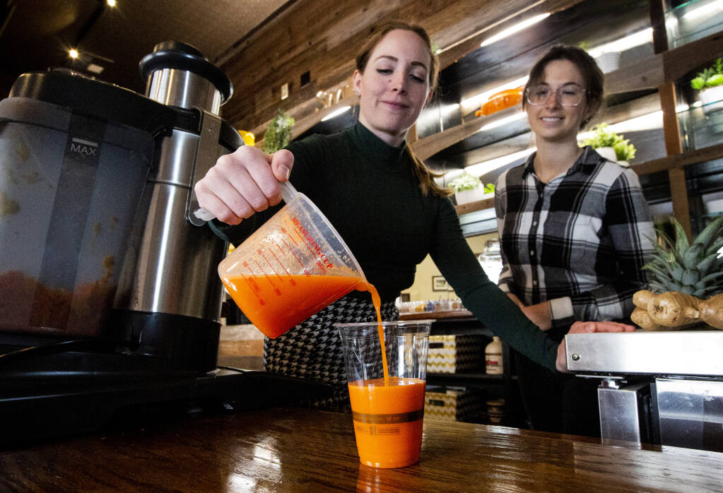 Cara McLaughlin, recipe developer and creative director, pours a freshly made Celtic Carrots drink at Sidecar juice bar on First Street East, opposite Murphy’s Irish Pub. Photo taken on Wednesday, March 8, 2023. (Robbi Pengelly/Index-Tribune)