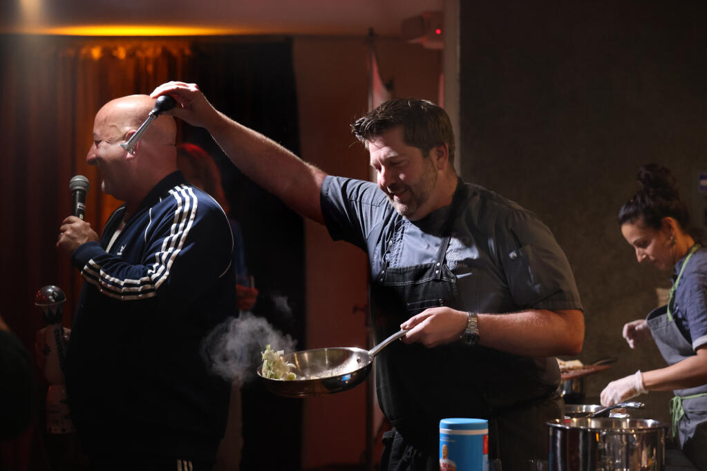 Chef Dustin Valette jokingly squeaks a bike horn in the ear of chef and judge Mark Stark during the 'Knife's Edge" competition during a fundraising dinner for Sonoma Family Meal at the Moose Lodge in Santa Rosa, Calif., Sunday, November 13, 2022. (Beth Schlanker/The Press Democrat)