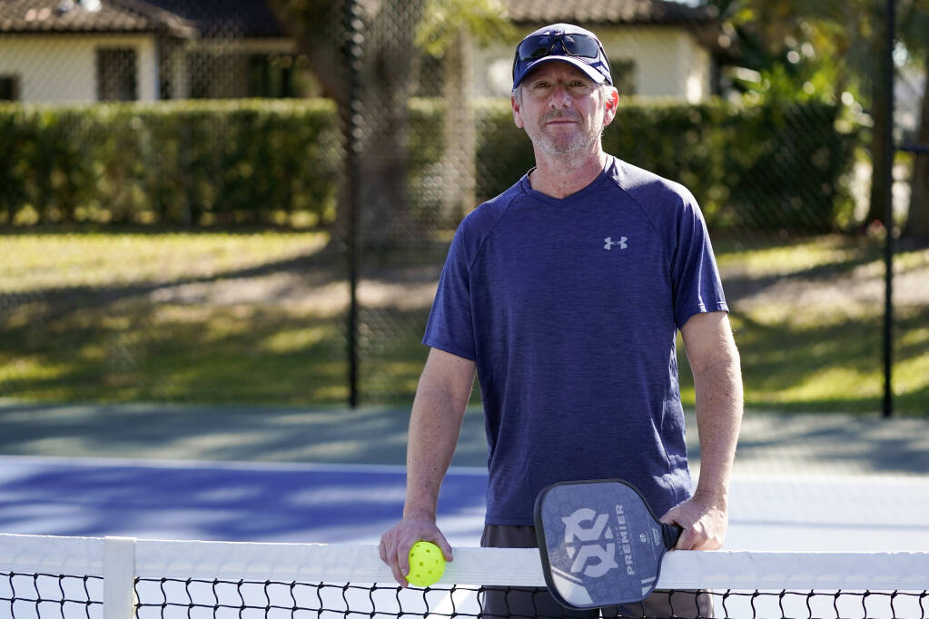 Owen Glick gets ready to play pickle ball at Phelps Park, Tuesday, Jan. 17, 2023, in Winter Park, Fla. Glick was among the 233,000 people who left a Western state for another U.S. state out of the region. The U.S. population center is on track this decade to take a southern swerve for the first time in history, and it's because of people like Glick, who moved from California to Florida more than a year ago. (AP Photo/John Raoux)