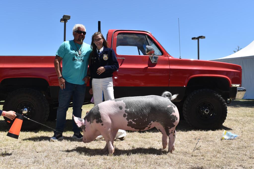 Guy Fieri, FFA senior member Frances Marshall and Chevy, the pig which Fieri purchased at Sunday’s auction. (Heidi Mickelson)