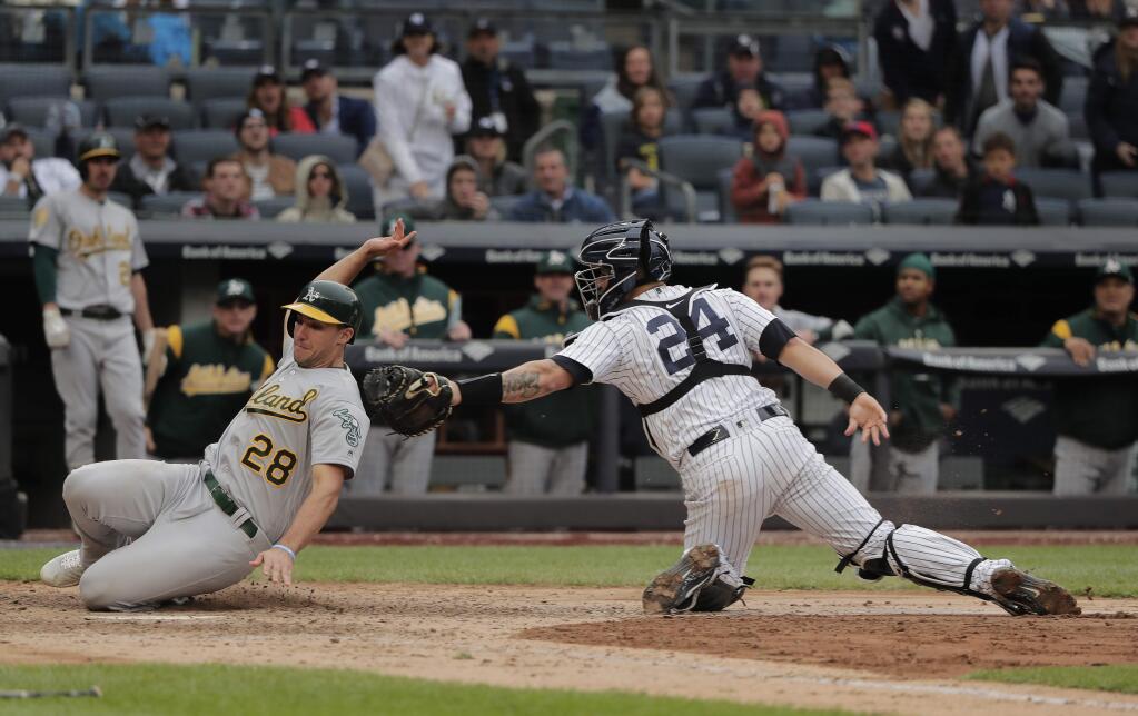 New York Yankees catcher Gary Sanchez tags out the Oakland Athletics' Matt Olson at the plate during the ninth inning Saturday, May 12, 2018, in New York. Olson attempted to score from third on a sacrifice fly by Jonathan Lucroy. (AP Photo/Julie Jacobson)