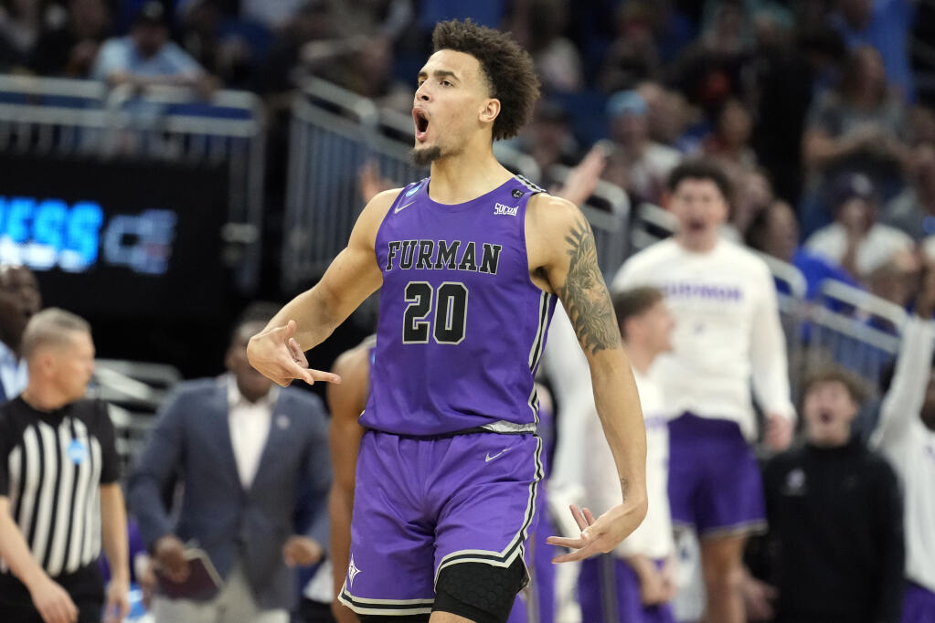 Furman forward Jalen Slawson (20) reacts after making a three-point shot against Virginia during the second half of a first-round college basketball game in the NCAA Tournament Thursday, March 16, 2023, in Orlando, Fla. Furman beat Virginia 68-67. AP Photo/Chris O'Meara)
