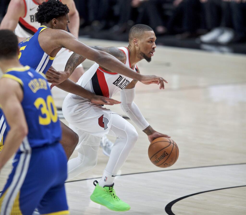Portland Trail Blazers guard Damian Lillard, right, dribbles past Golden State Warriors center Damian Jones during the first half of Game 3 of the NBA basketball playoffs Western Conference finals Saturday, May 18, 2019, in Portland, Ore. (AP Photo/Craig Mitchelldyer)