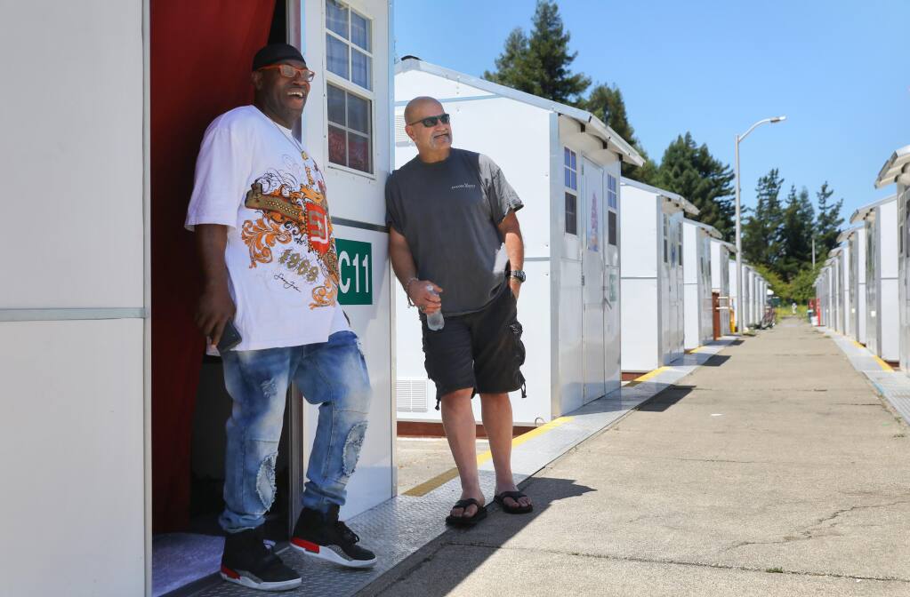 Residents Kenneth Jones, left, and Steve Toleson talk at the Los Guilicos Village outdoor homeless shelter in Santa Rosa on Wednesday, July 1, 2020.  (Christopher Chung / The Press Democrat)