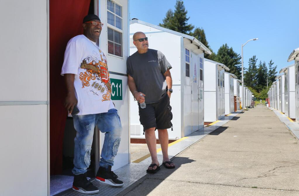 Residents Kenneth Jones, left, and Steve Toleson talk at the Los Guilicos Village outdoor homeless shelter in Santa Rosa on Wednesday, July 1, 2020.  (Christopher Chung / The Press Democrat)