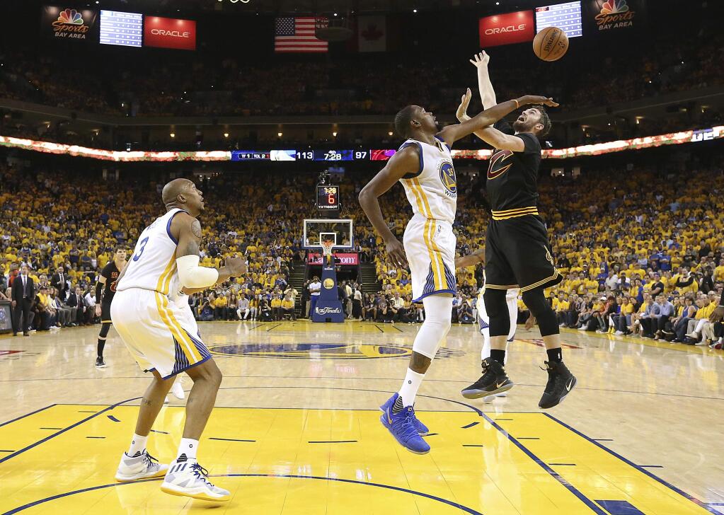 Golden State Warriors forward Kevin Durant, center, defends a shot by Cleveland Cavaliers forward Kevin Love during the second half of Game 2 of basketball's NBA Finals in Oakland, Calif., Sunday, June 4, 2017. (Ezra Shaw/Pool Photo via AP)