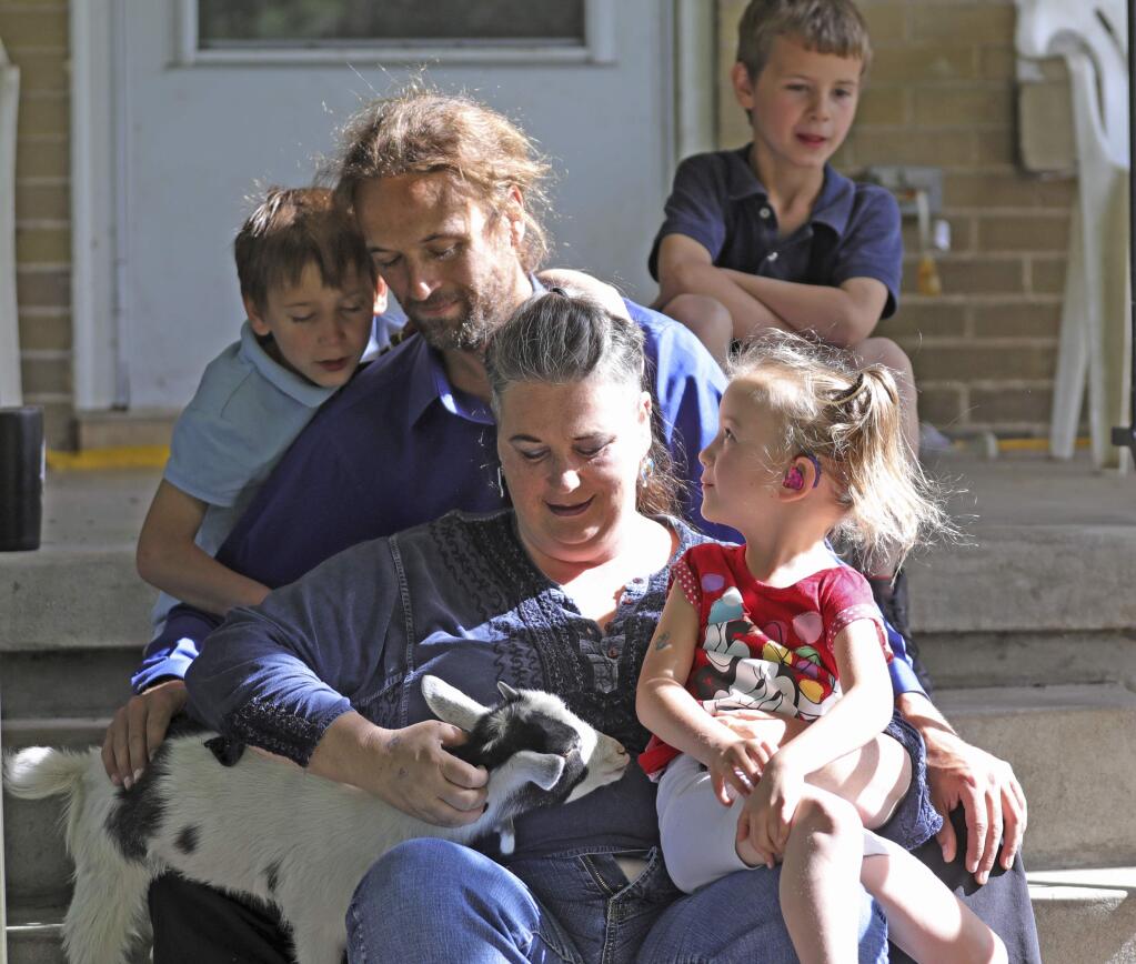In this Thursday, June 6, 2019, photo, from left to right, Richard, dad Michael and mom Amie, Ethan, rear, and Victory, gather on the steps of their home, in Ogden, Utah. When doctors said her youngest child would be a girl, Amie Schofield chose the name Victoria. Then the prediction changed to boy, so she switched to Victor. It turned out neither was exactly right: The blue-eyed baby was intersex, with both male and female traits. She and her husband decided to call the infant Victory. The name is a hopeful promise for triumph over the secrecy and shame, the pain and discrimination suffered by intersex people. (AP Photo/Rick Bowmer)