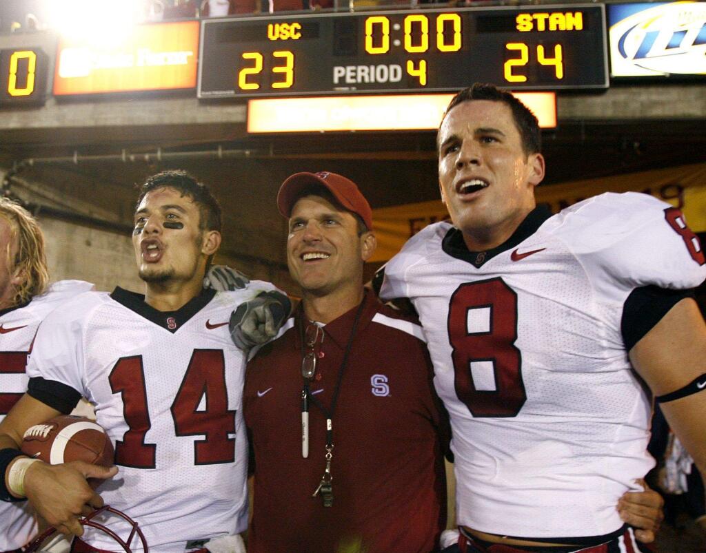 In this Oct. 6, 2007, file photo, from left, Stanford's Tavita Pritchard, coach Jim Harbaugh, and Evan Moore celebrate after Stanford upset USC 24-23 in Los Angeles. (AP Photo/Matt Sayles, File)