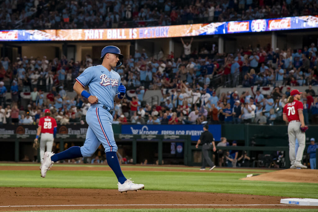 Texas Rangers' Josh Jung, front left, rounds the bases after hitting a solo homer in the bottom of the second inning in a baseball game against the Philadelphia Phillies in Arlington, Texas, Sunday, April 2, 2023. (AP Photo/Emil T. Lippe)