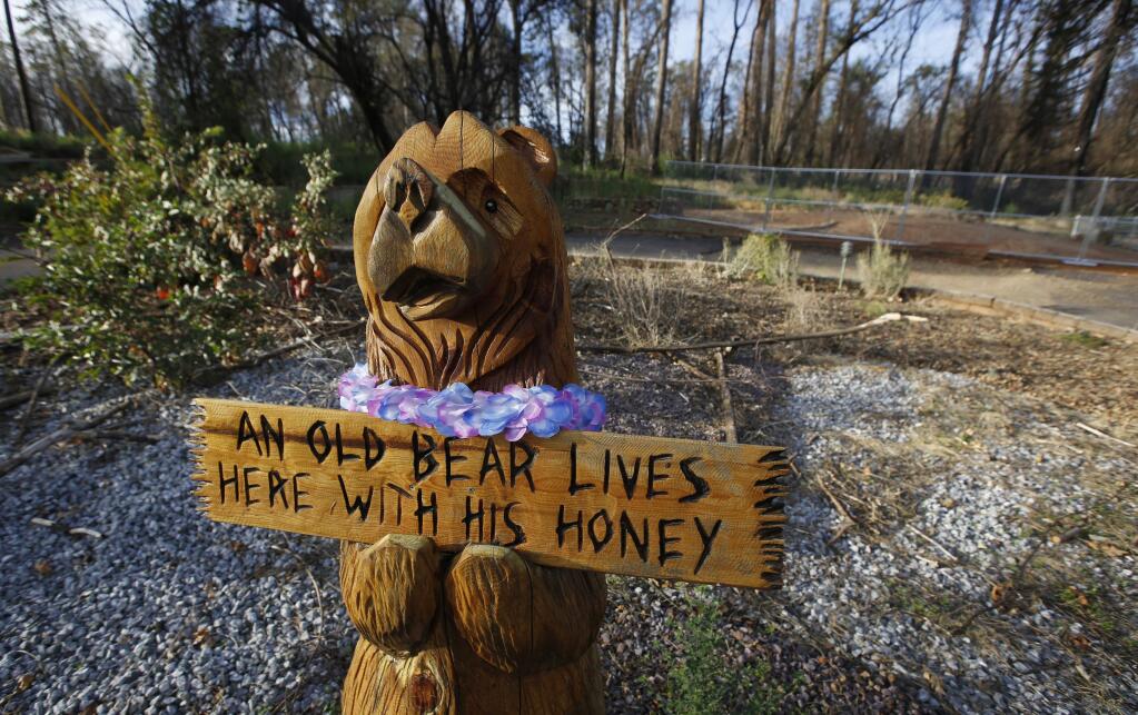 FILE - In this Thursday, Oct. 24, 2019, photo, a wooden bear still stands at a home that was lost in last year's Camp Fire in Paradise, Calif. Only a handful of homes have been rebuilt in the community that lost nearly 9,000 residences in last year's Camp Fire. (AP Photo/Rich Pedroncelli)