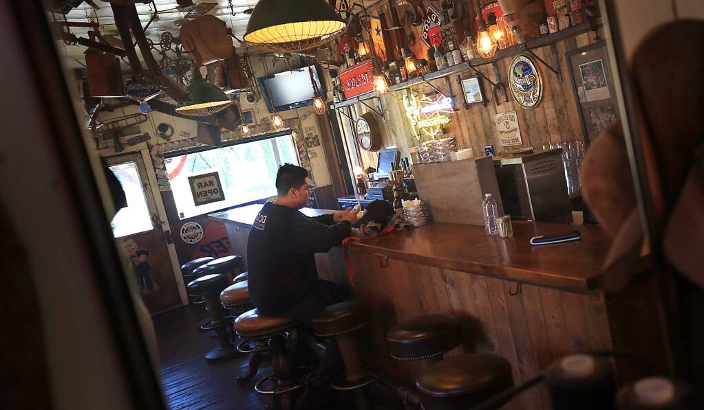 A Dry Creek General Store employee takes a break at the closed bar on Thursday, July 6, 2017. (KENT PORTER/ PD)