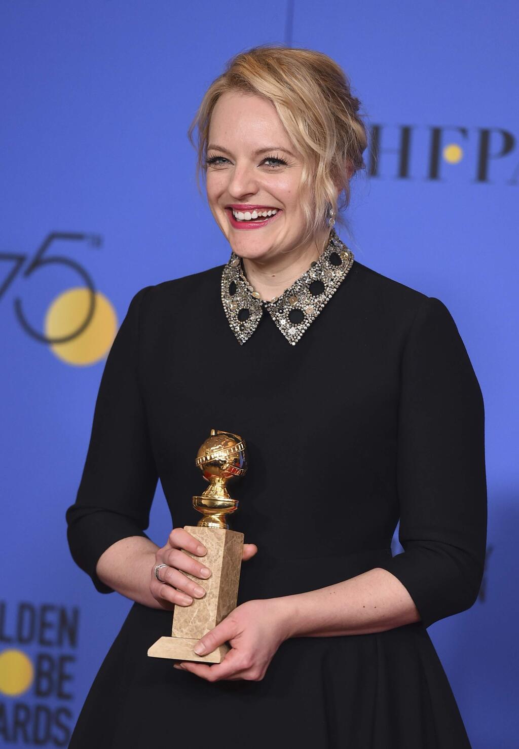 Elisabeth Moss poses in the press room with the award for best performance by an actress in a television series - drama for 'The Handmaid's Tale' at the 75th annual Golden Globe Awards at the Beverly Hilton Hotel on Sunday, Jan. 7, 2018, in Beverly Hills, Calif. (Photo by Jordan Strauss/Invision/AP)