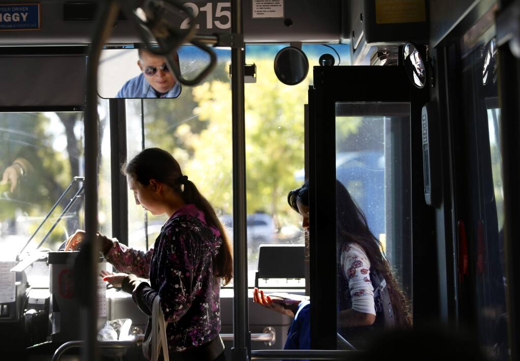 A Santa Rosa Junior College student Olivia boards a Sonoma County Transit bus at the bus stop on Mendocino at Pacific avenues in Santa Rosa. (BETH SCHLANKER / The Press Democrat, 2014)