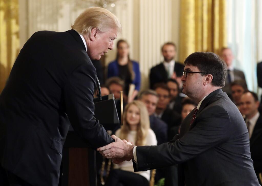 President Donald Trump shakes hands with Acting Veterans Affairs Secretary Robert Wilkie, during an event on prison reform in the East Room of the White House, Friday, May 18, 2018, in Washington. Trump announced he's nominating Acting Veterans Affairs Secretary Robert Wilkie to lead the agency. (AP Photo/Evan Vucci)