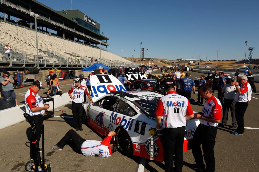 Crew members work on the Mobil 1 Ford driven by Kevin Harvick on Saturday in preparation for qualifying for the Monster Energy NASCAR Cup Series Toyota/Save Mart 350 race at Sonoma Raceway on Saturday, June 23, 2018. (Alvin Jornada / The Press Democrat)