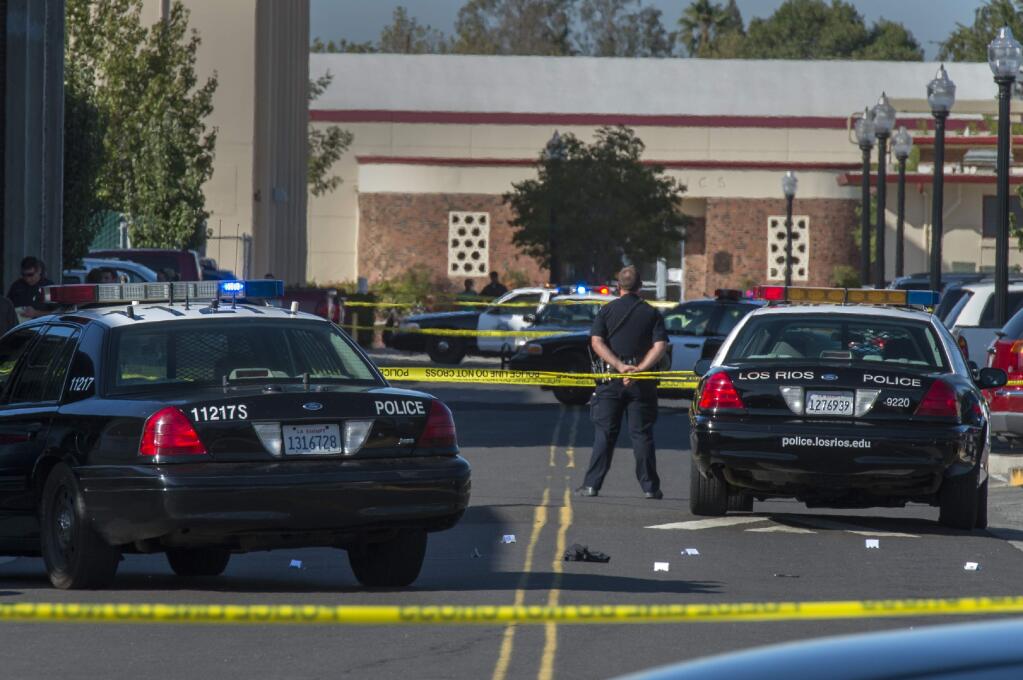 A police officer stands guard as Sacramento City College is on lockdown while police search the area after a shooting, Thursday, Sept. 3, 2015, in Sacramento, Calif. The shooting occurred in a parking lot near the baseball field on the college campus. The campus has since been reopened. (Renée C. Byer/The Sacramento Bee via AP)