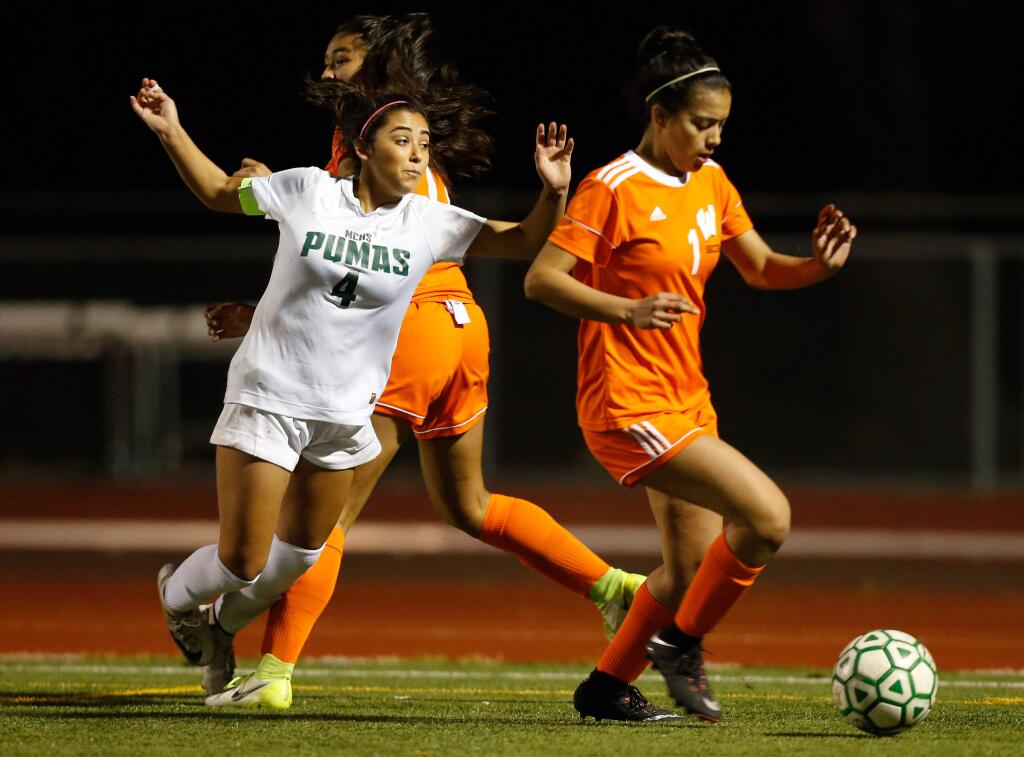 Maria Carrillo forward Kitana Gonzalez (4), left, is tripped by Woodland's Celestina Castaneda (17) just outside the Woodland goal box as Gonzalez tries to get the ball back from Woodland's Grace Cleaver (1), right, during overtime in the CIF NorCal Division 2 girls soccer semifinal match in Santa Rosa on Thursday, March 8, 2018. (Alvin Jornada / The Press Democrat)