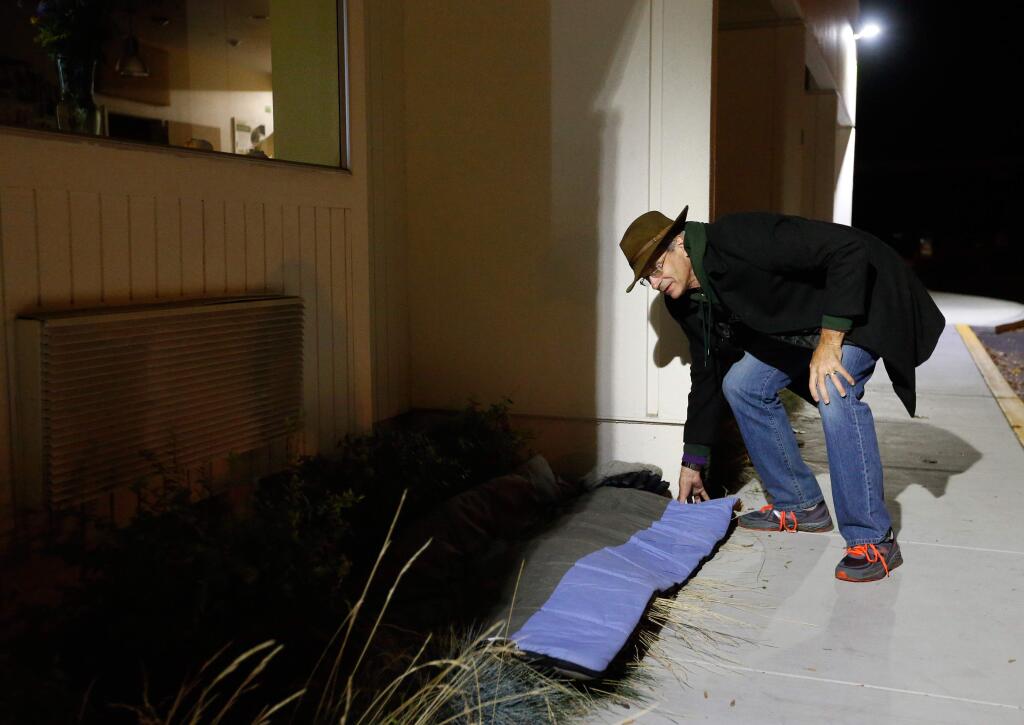 Keith Becker lays out his bedroll in a quiet spot outside the Social Advocates for Youth Dreamcenter as he participates in Social Advocates for Youth's One Cold Night event at the SAY Dreamcenter in Santa Rosa, California on Friday, November 18, 2016. (Alvin Jornada / The Press Democrat)