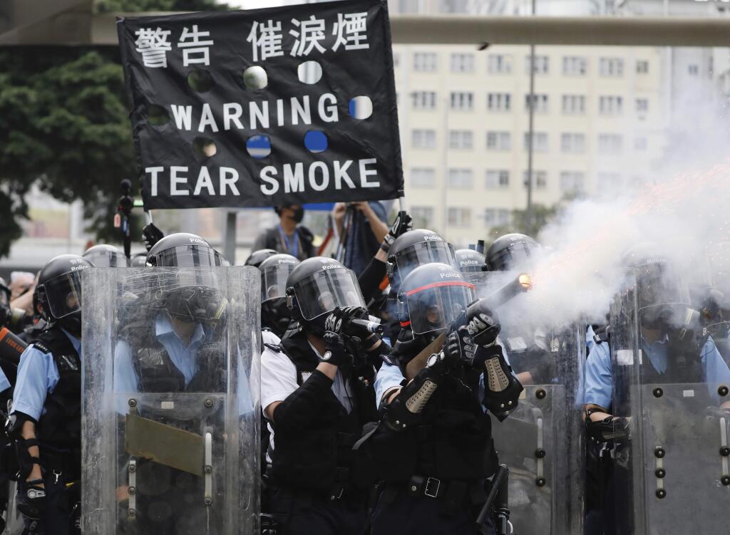 Police fire tear gas towards protesters outside the Legislative Council in Hong Kong, Wednesday, June 12, 2019. Hong Kong police used tear gas and high-pressure water hoses against protesters who had massed outside government headquarters Wednesday in opposition to a proposed extradition bill that has become a lightning rod for concerns over greater Chinese control and erosion of civil liberties in the semiautonomous territory. (AP Photo/Vincent Yu)