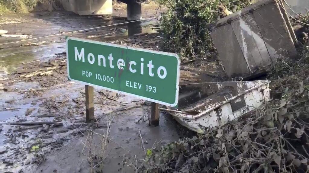 In this Monday, Jan. 15, 2018 image from video provided by the Santa Barbara County Fire Department, the U.S. 101 freeway remains underwater as clean-up crews work to clear the roads throughout Montecito, Calif., following the deadly mudflow and flooding Jan. 9. Crews working around the clock cleared boulders, trees and crushed cars from all lanes of U.S. 101, but California officials still weren't sure Monday when the key coastal highway might reopen after being inundated during mudslides that killed 20 people. (Mike Eliason/Santa Barbara County Fire Department via AP)