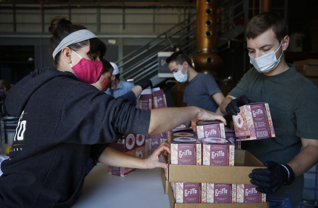 Employees Michelle Check and Sebastien Pochari package cans of the vodka cocktail "Whole Lotta Sunshine" at Griffo Distillery and Tasting Bar in Petaluma, Calif., on Tuesday, June 8, 2021.(Beth Schlanker/The Press Democrat)