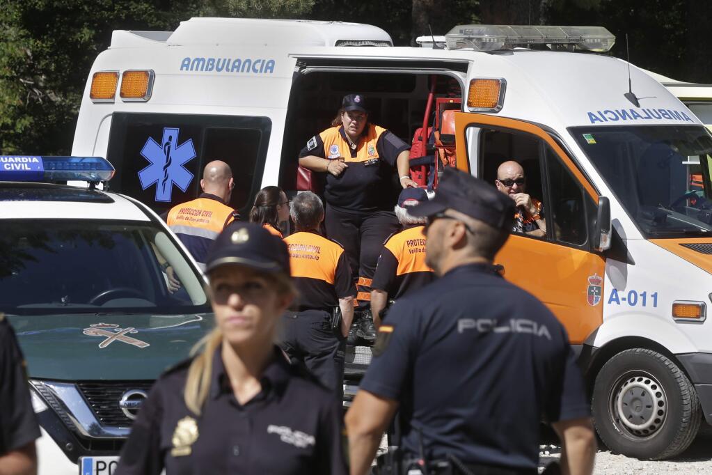 Police and medics wait near a woodland area in Cercedilla, just outside of Madrid, Spain, Tuesday, Sept. 3, 2019. A search squad of hundreds is combing a mountainous area outside Madrid 11 days after former alpine ski racer and Olympic medalist Blanca Fernandez Ochoa went missing.(AP Photo/Paul White)