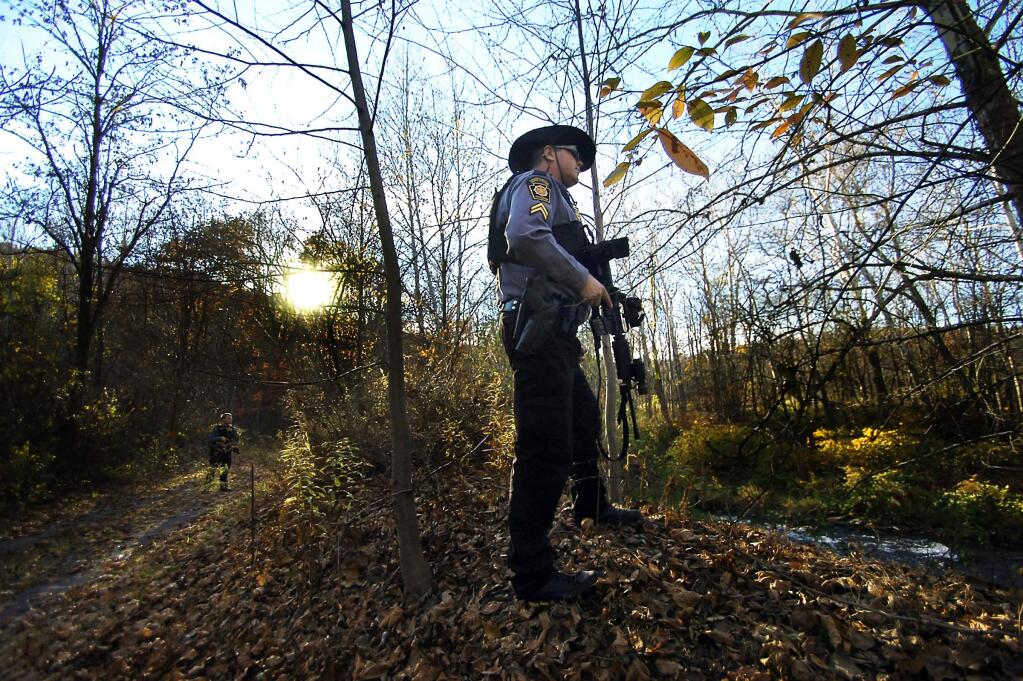 Pennsylvania State Police Trooper's search the woods near Route 191 in Henryville, Pa., on Monday, Oct. 27, 2014, during the massive manhunt for suspected killer Eric Frein. Frein was located and captured Thursday, Oct. 30, 2014. (AP Photo / The Scranton Times-Tribune, Butch Comegys)