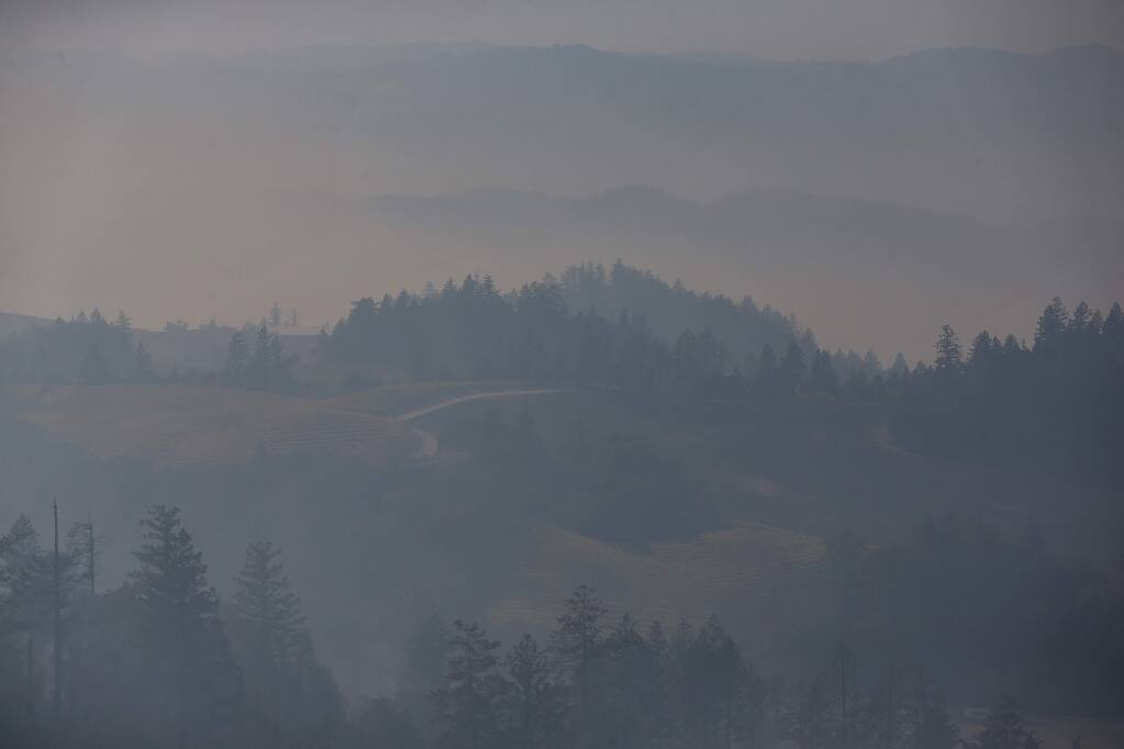 A thick haze of smoke engulfs the valley below Geysers Road, near Geyserville, on Friday, October 25, 2019. (Christopher Chung/ The Press Democrat)