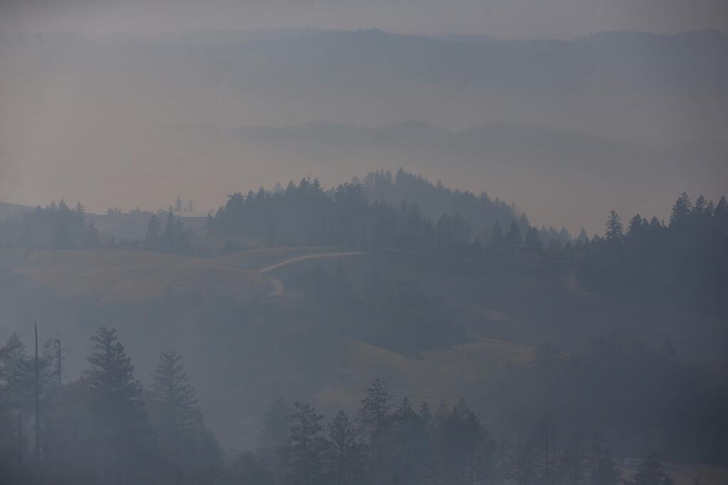 A thick haze of smoke engulfs the valley below Geysers Road, near Geyserville, on Friday, October 25, 2019. (Christopher Chung/ The Press Democrat)