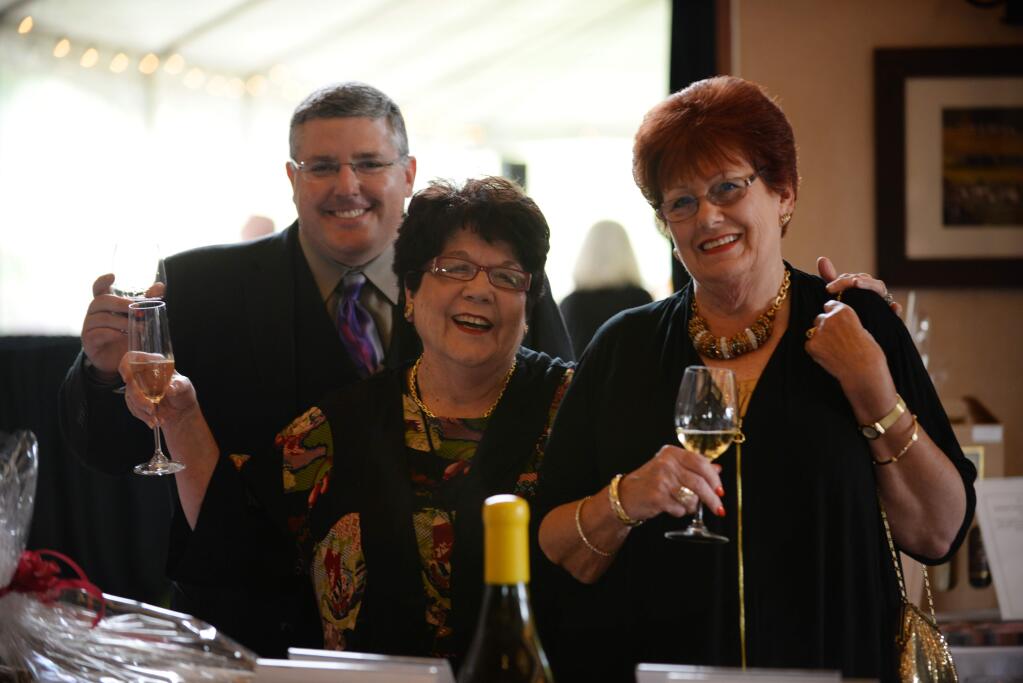 From left, Mike Tonelli, Ora Romani and Marlene Bertram in the silent auction area during Lights, Camera, Auction! the annual fundraiser benefiting the Kenwood Education Foundation held Saturday evening at St. Francis Winery & Vineyards in Santa Rosa. April 22, 2017. (Photo: Erik Castro/for The Press Democrat)