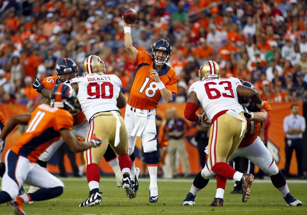 Denver Broncos quarterback Peyton Manning (18) throws as San Francisco 49ers defensive tackle Darnell Dockett (90) and Tony Jerod-Eddie (63) rush during the first half of a game, Saturday, Aug. 29, 2015, in Denver. (AP Photo/Jack Dempsey)