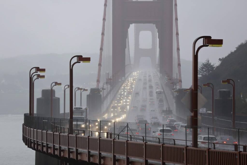 FILE - In this Jan. 5, 2016, file photo, traffic crosses the Golden Gate Bridge in the rain in this view from Sausalito, Calif. Northern California's iconic Golden Gate Bridge will cost southbound motorists and additional quarter to cross starting July 1, 2018. The Marin Independent Journal reported Saturday, May 19, 2018, that the toll hike will mean some drivers will pay as much as $8 to travel from Marin County to San Francisco. (AP Photo/Eric Risberg)