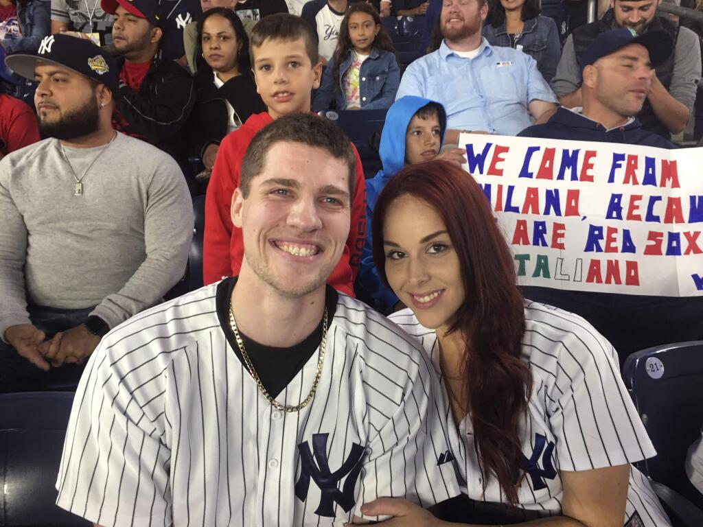Andrew Fox, left, and Heather Terwilliger sit in the stands at Yankee Stadium on Tuesday night, Sept. 27, 2016, in New York. When Fox pulled the ring from his pocket and dropped to one knee before Terwilliger to propose during the fifth inning of the Yankees' game, the ring dropped to the ground. A frantic search ensued. After about five minutes, Terwilliger looked down and saw something shiny in the cuff of her pants leg. (Scott Orgera via AP)