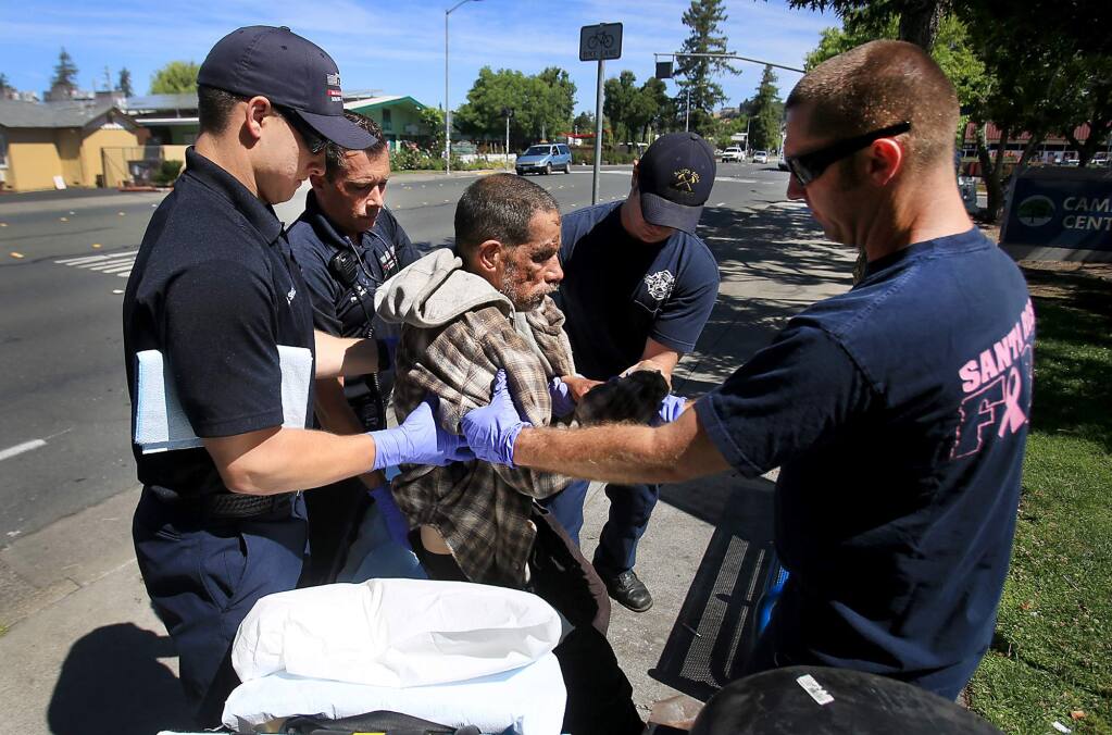 Santa Rosa firefighters assist homeless resident Teddy Lamantia on College Avenue near Santa Rosa Junior College, Tuesday June 21, 2016. (Kent Porter / Press Democrat) 2016
