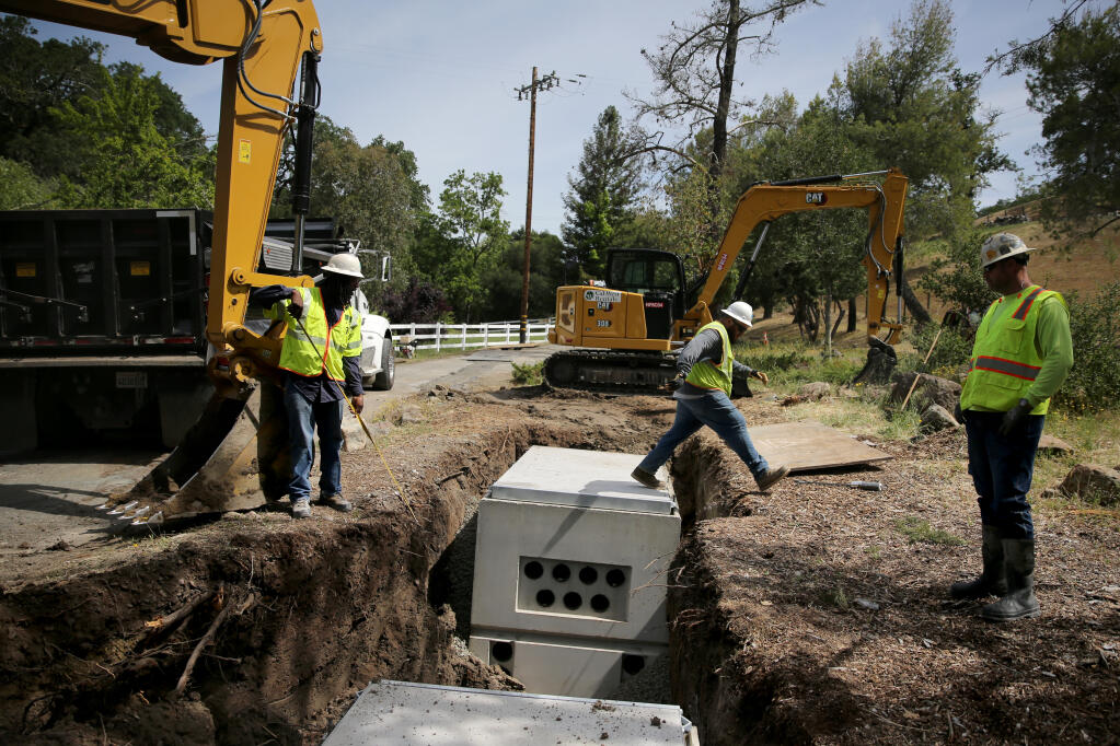 PG&E employees measure the width of the excavation for an underground splice box and transformer at the intersection of Porter Creek Road and Loch Haven Drive in Santa Rosa, Tuesday, June 7, 2022. (Beth Schlanker / The Press Democrat file)